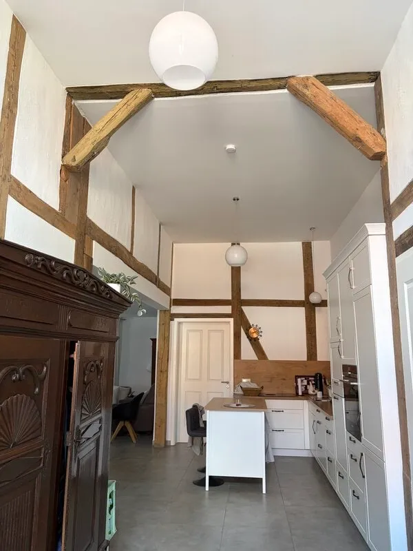 Küche im Fachwerkhaus mit weißen Wänden und freigelegten Holzbalken